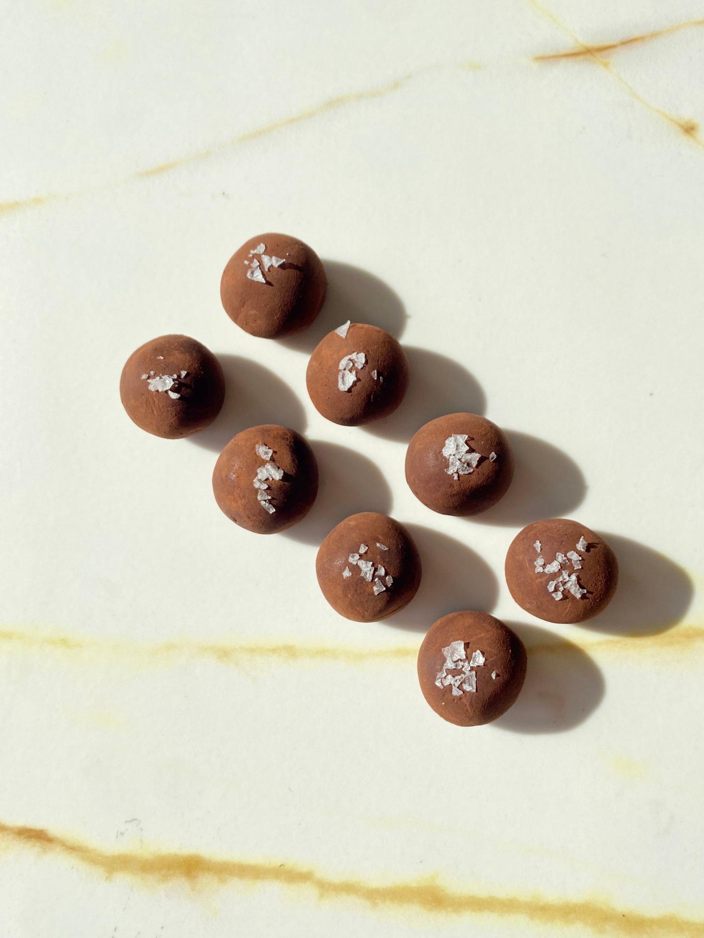 Close-up of organic chocolate date truffle with flaky sea salt, designed for mums-to-be