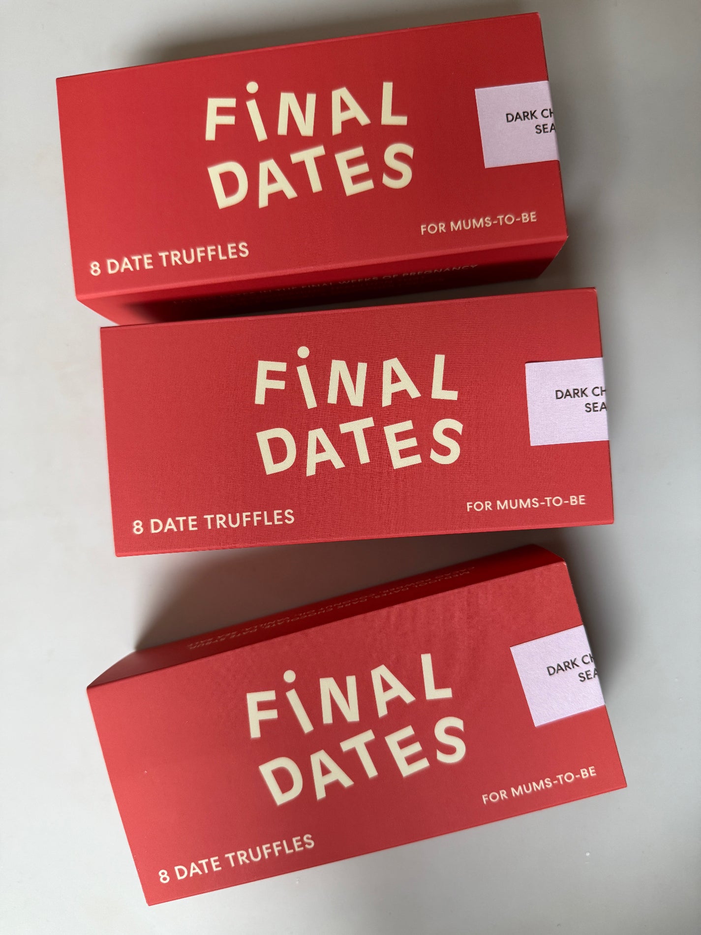 Three red boxes of 'Final Dates' date truffles on a light gray background