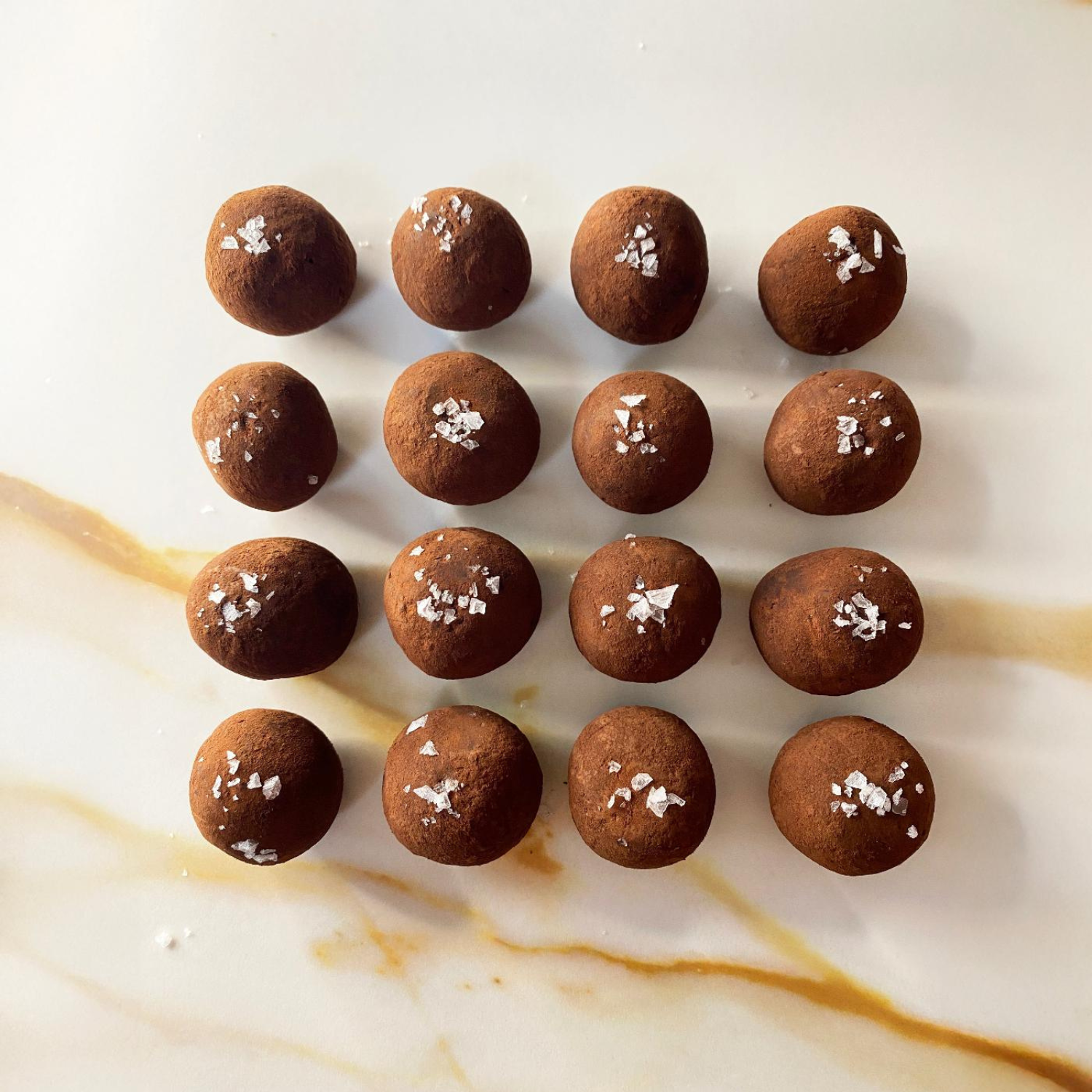 Chocolate truffles with sea salt on a marble surface
